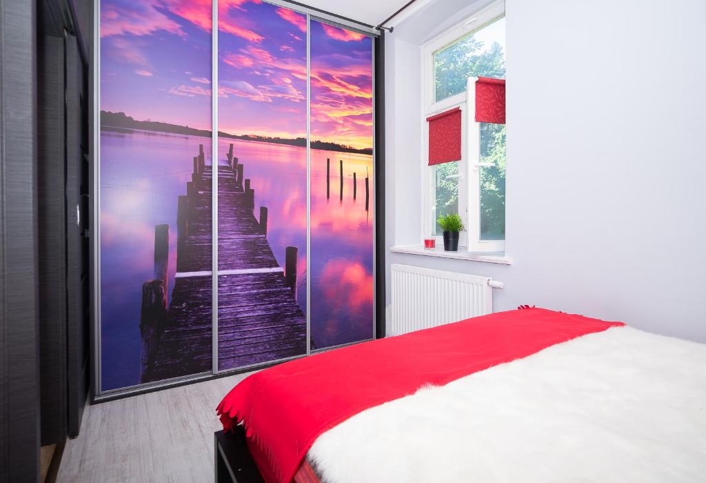 a bedroom with a large painting of a pier at Apartament Sopot Kamienny Potok in Sopot