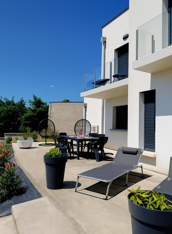 une terrasse avec un banc, une table et des chaises dans l'établissement Grande villa moderne, à Moyrazès