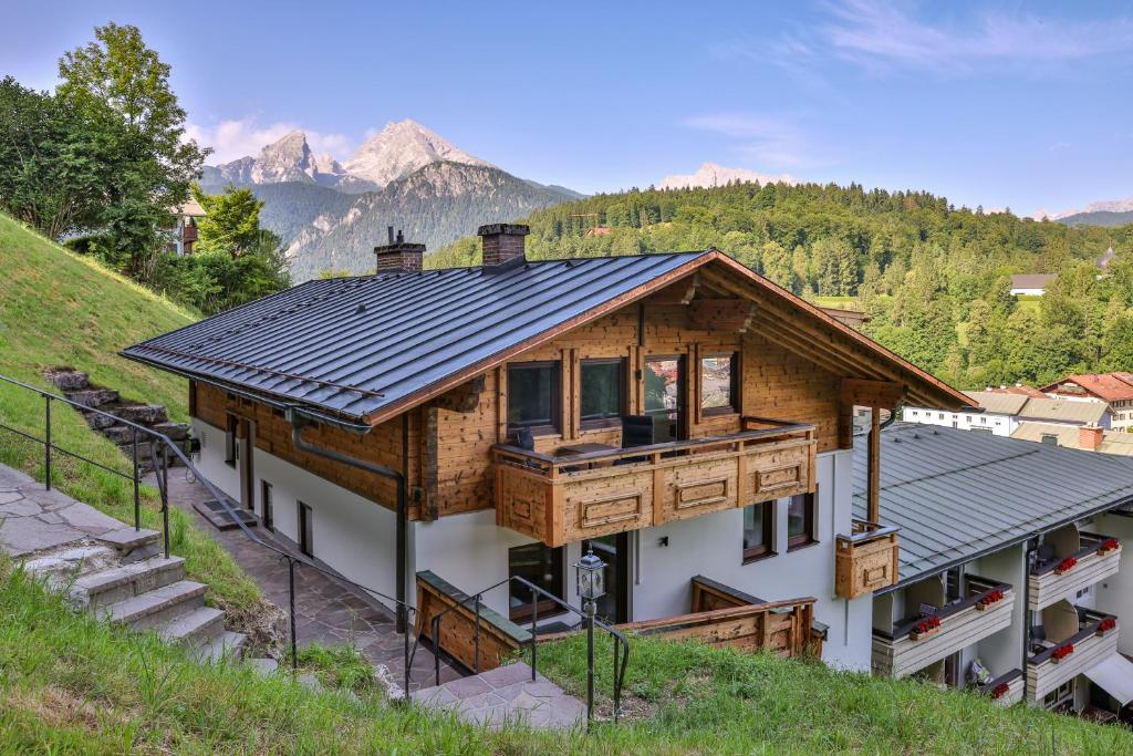 a house with a metal roof on a mountain at Ferienwohnungen - Alpenhotel Fischer 4 Sterne - Adults Only in Berchtesgaden