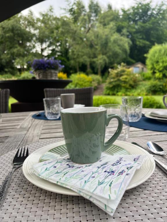 un tavolo con una tazza di caffè e piatti sopra di "Un matin au jardin" a Francorchamps