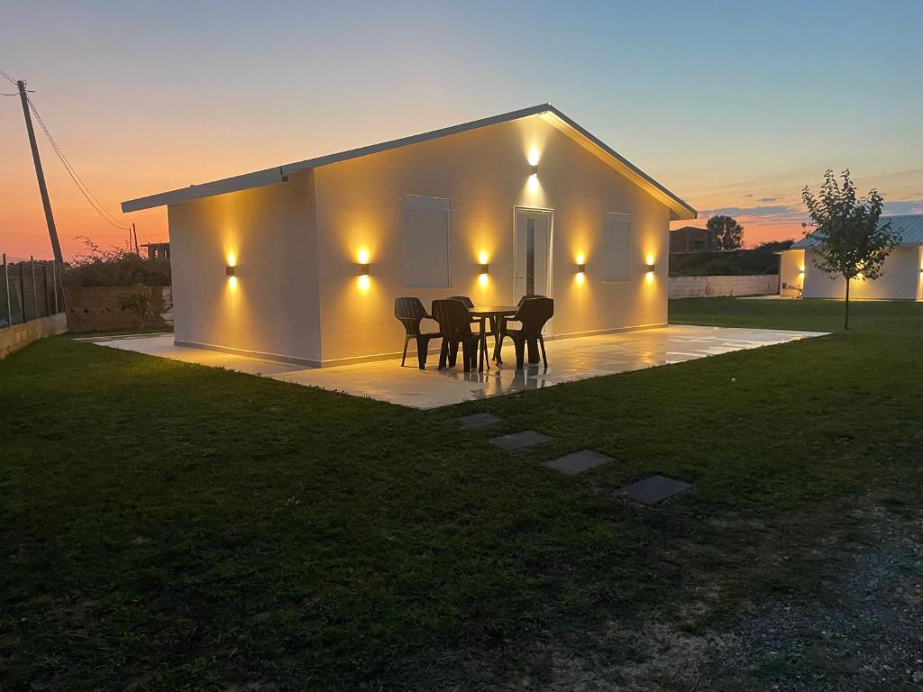 a house with a table and chairs in front of it at Garden beach house in Hamallë