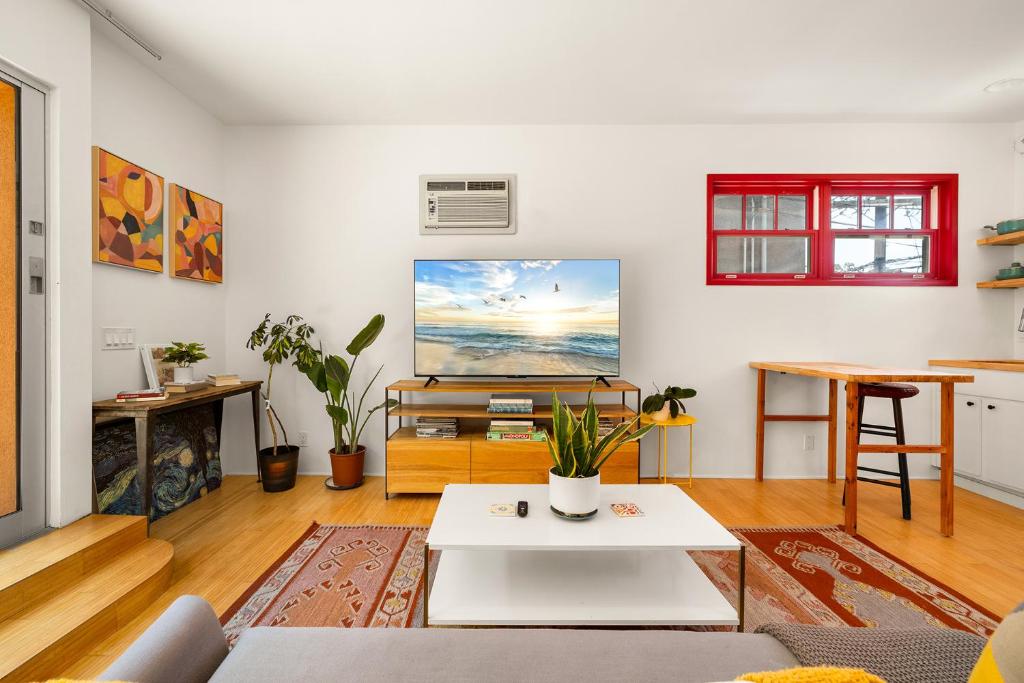 sala de estar con mesa blanca y TV en Artsy Venice Beach Canals Studio w/Rooftop & Sauna, en Los Ángeles