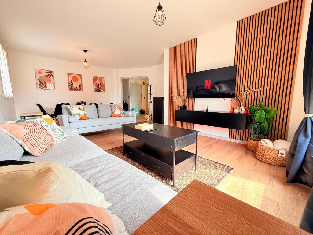 a living room with two couches and a tv at Maison rénové 10 prsn Parking privée & Balcon Proche Gare-Viotte in Besançon