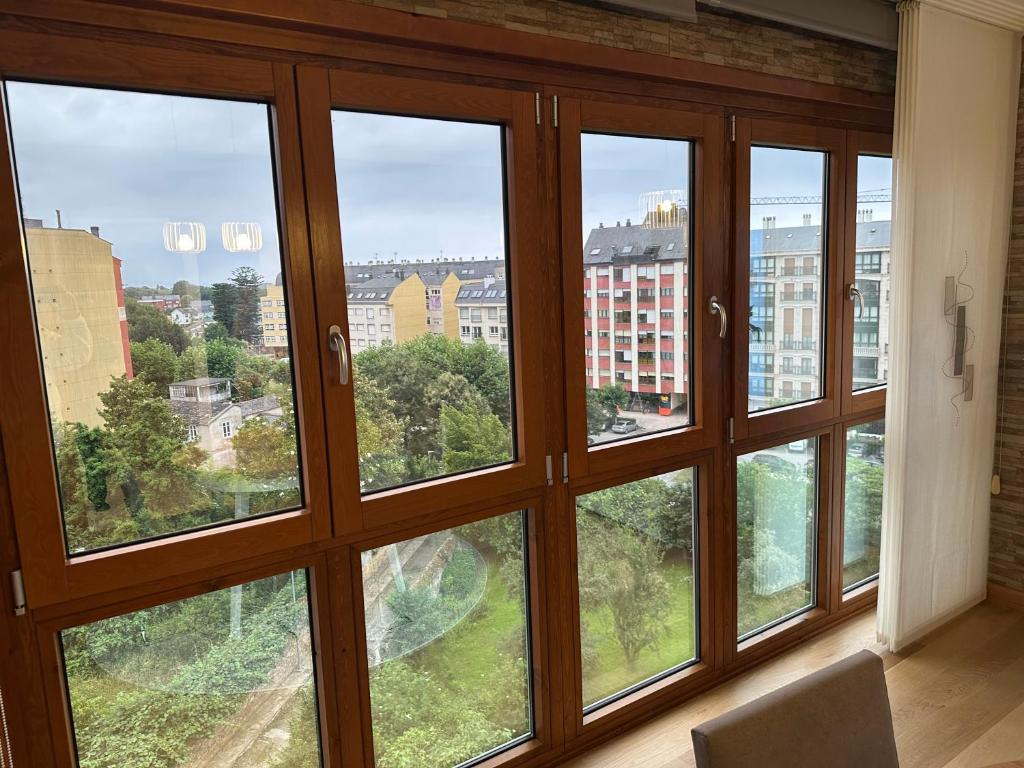 a room with four windows with a view of a city at #Las Azaleas# in Ribadeo