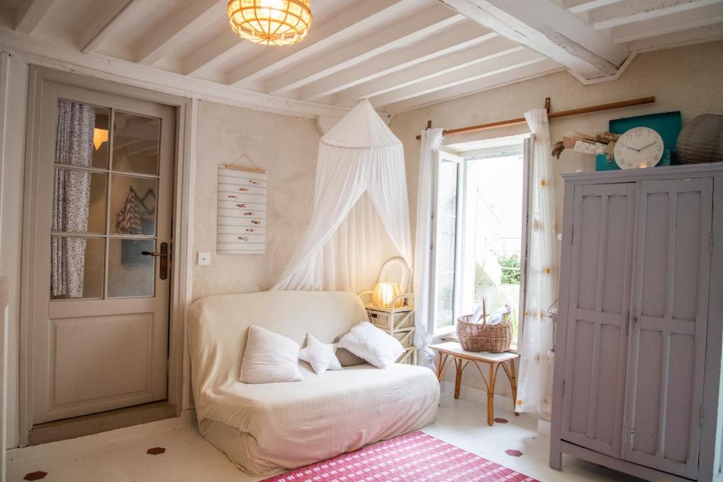 Cette chambre comprend une chaise blanche et une fenêtre. dans l'établissement Charm and comfort, à La Celle-sous-Gouzon