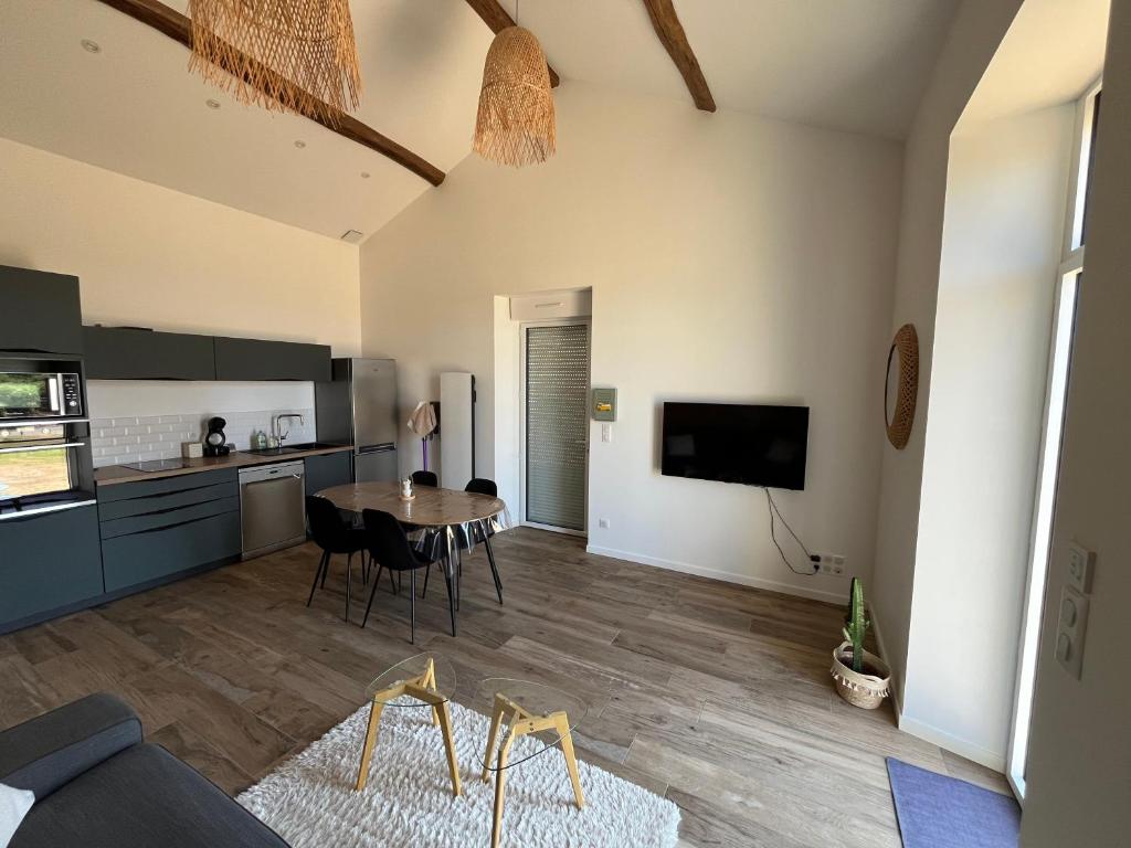 un salon avec une table et une cuisine dans l'établissement La petite maison de campagne, à La Celle-sous-Gouzon