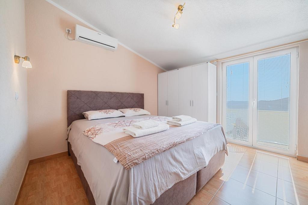 a bedroom with a large bed and a large window at Apartment Dragicevic 7 with Garage in Budva