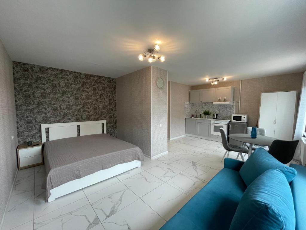 a bedroom with a bed and a blue couch at ''Kristall'' in Ventspils