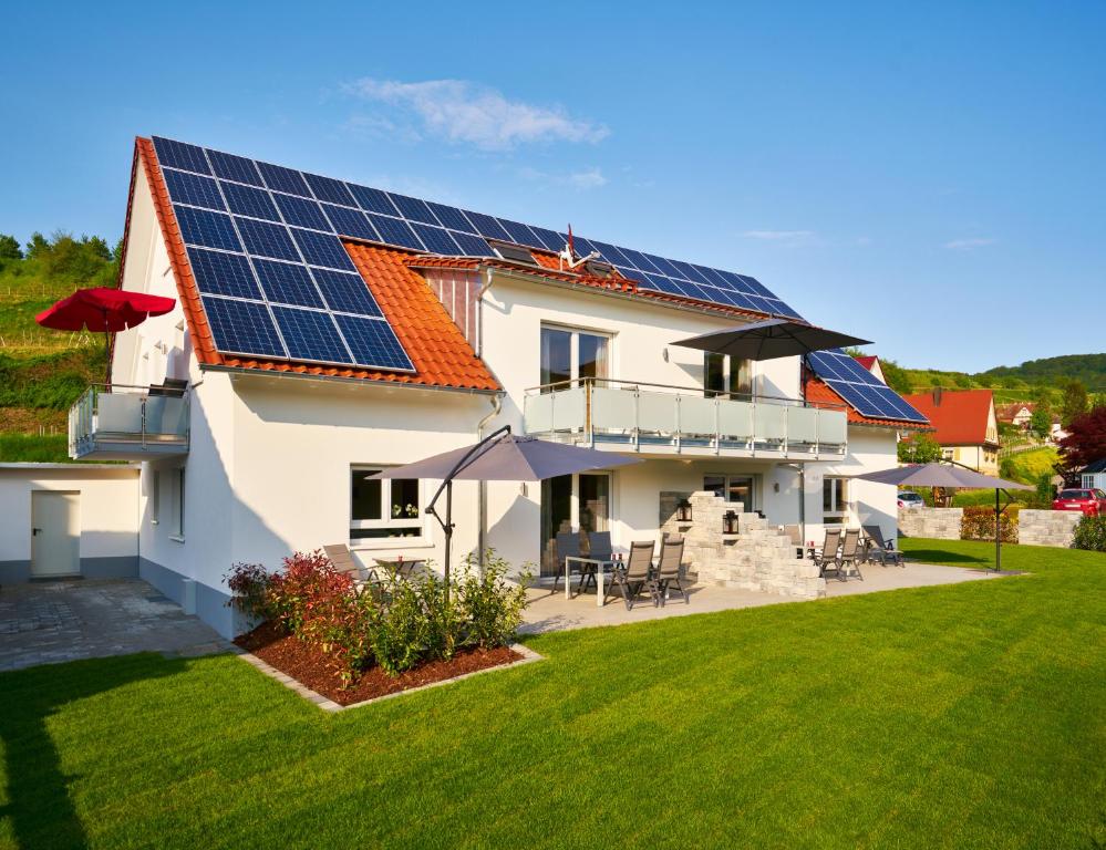 une maison avec des panneaux solaires sur le toit dans l'établissement Müller s Ferienhäusle UG, à Vogtsburg im Kaiserstuhl