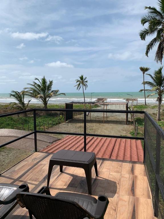 a patio with a table and chairs and the beach at Hostal pura vida in San Bernardo del Viento