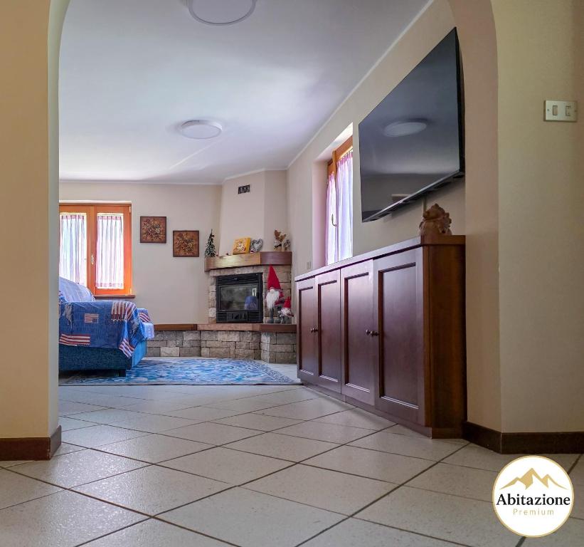 a living room with a tv and a fireplace at Casa con giardino e garage vicino alle piste in San Pietro