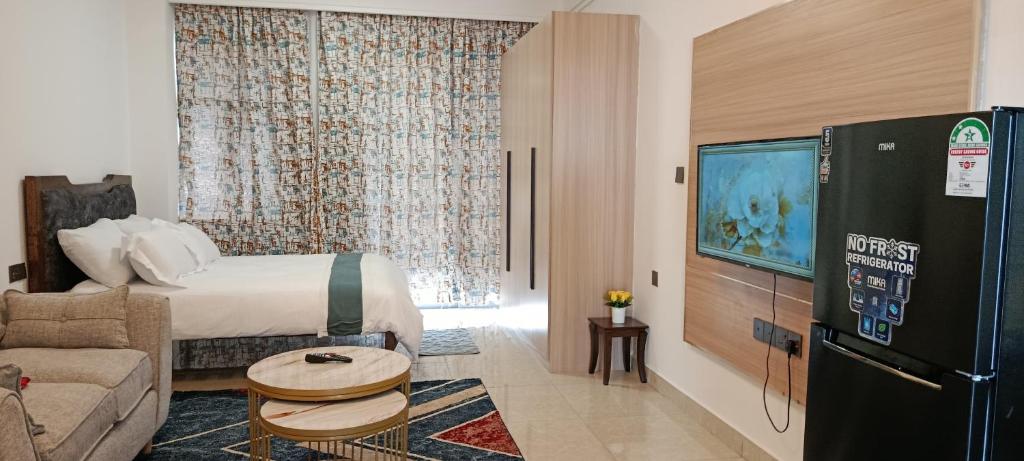 een hotelkamer met een bed en een tv bij Cozy Ruaka Retreat in Ruaka