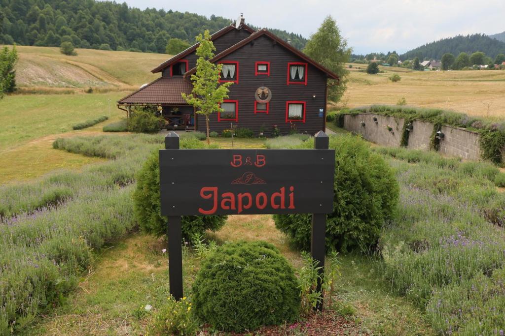 马考巴尔贾Boutique B&B Japodi的田野里一栋小房子前的标志