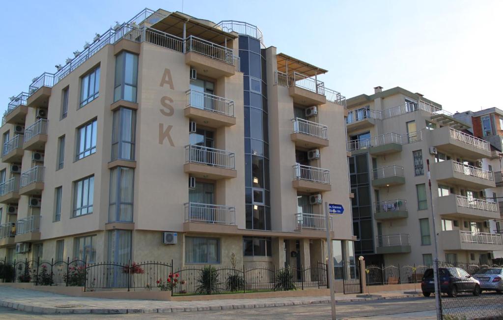 an apartment building with a sign on the side of it at Guest House ASK in Primorsko