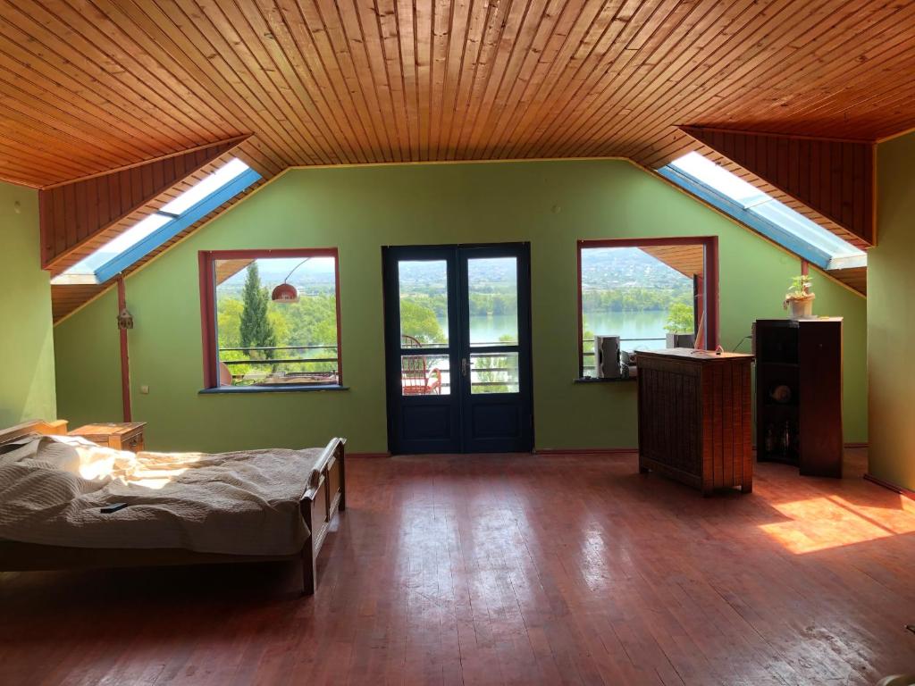 Cette grande chambre comprend un lit et une lucarne. dans l'établissement Vintage, à Natakhtari