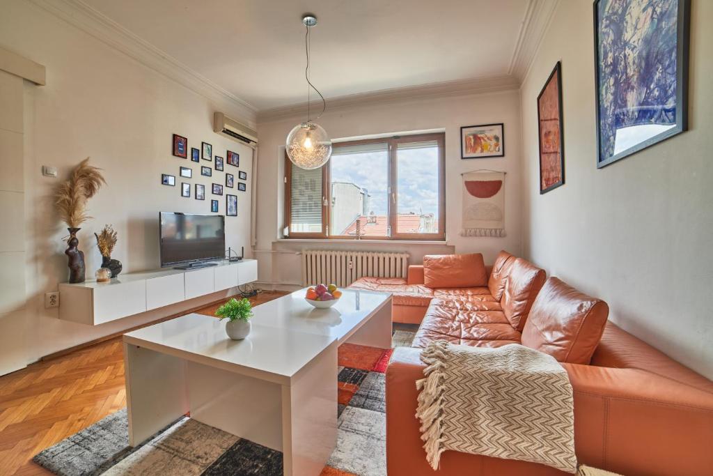 a living room with a couch and a table at Main Street Sunshine 2 KING Bdr in Sofia