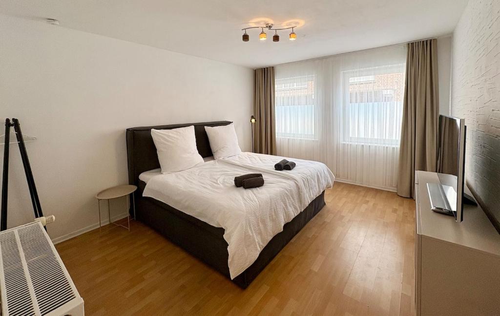 a bedroom with a large bed with white sheets at Zentral, stilvoll, für 4 Personen, familienfreundlich in Emmerich