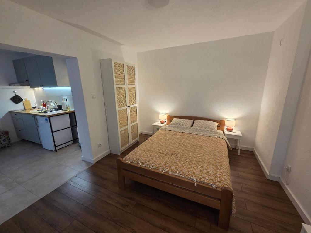 a bedroom with a bed and two lamps on two tables at Studio Sanader in Soko Banja