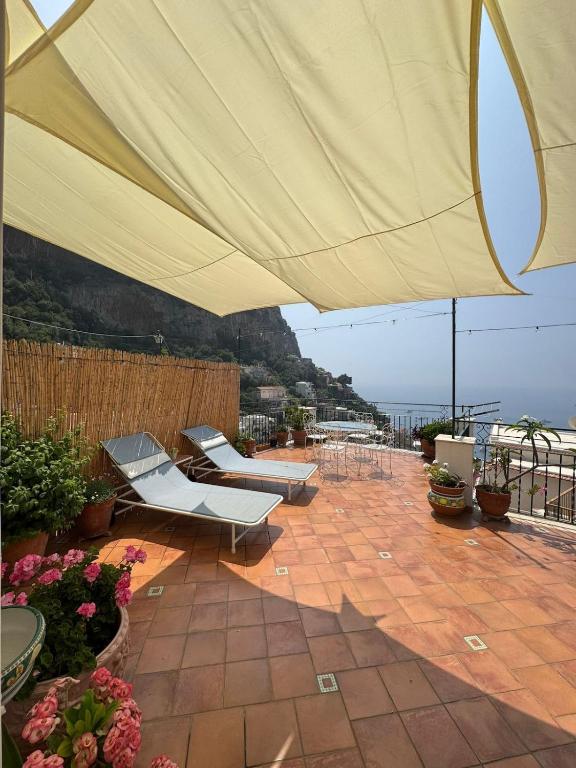 a patio with a large umbrella and chairs and flowers at Casa Vivì in Positano