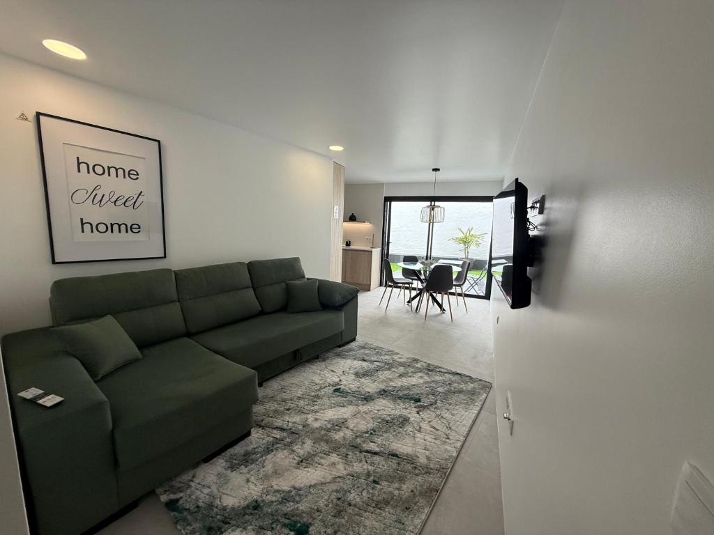ein Wohnzimmer mit einer grünen Couch in einem Zimmer in der Unterkunft Casa do Lago das Freiras in Ribeira Grande