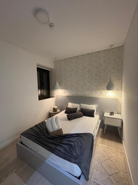a bedroom with a large white bed with two pillows at Family Hostel Costa Nova in Costa Nova