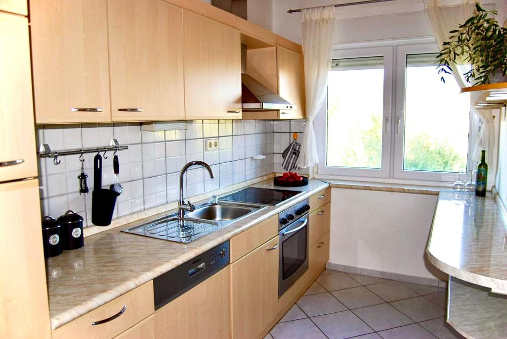 a kitchen with wooden cabinets and a sink and a window at Villa Forever More in Kaštela