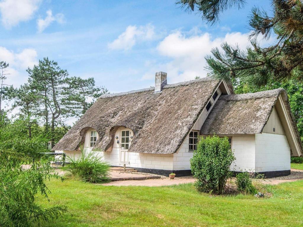 an old white house with a thatched roof at 5 person holiday home in Ringkøbing-By Traum in Nørby