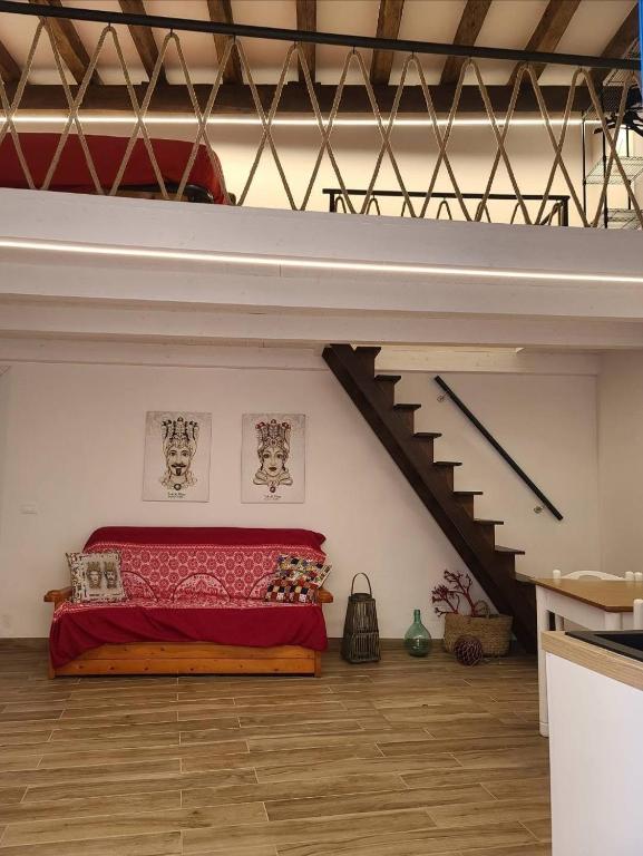 a bedroom with a red bed in a loft at Appartamento Nonno Pit, Marettimo in Marettimo