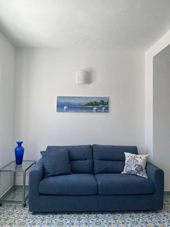 a blue couch sitting in a living room at Perla Bianca Holiday Home, Forio in Forio d'Ischia