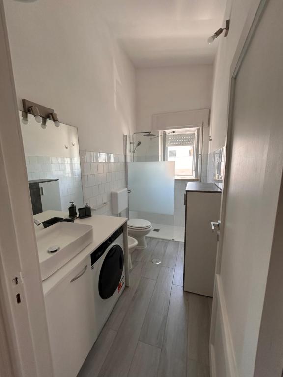 Un baño blanco con lavabo e inodoro. en Villa PO, en Torre Santa Sabina