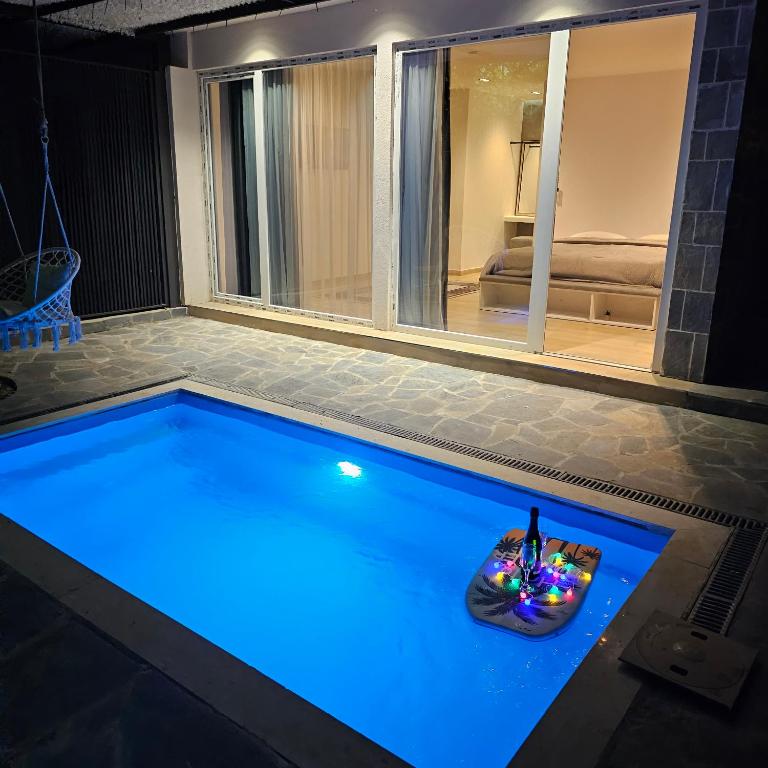 a swimming pool with blue lighting in a house at Riverside Private Pool&Halal Suite in Shkodër