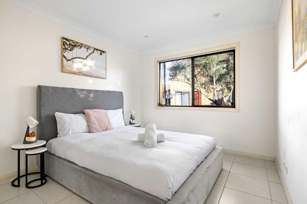 利物浦Convenient 2BR Nest in Liverpool - Stay with Ease的卧室里有一张白色的大床，床边有一扇窗户