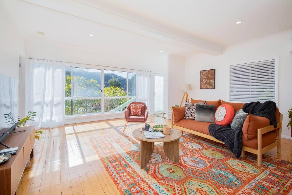 un soggiorno con un divano arancione e un tavolo di Serena Cottage - Sunlit Escape by Woy Woy Bay Wharf a Woy Woy