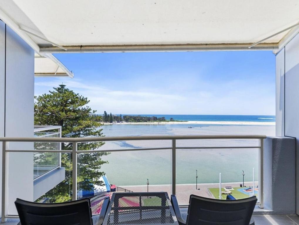 a balcony with chairs and a view of the ocean at The Entrance Waterfront Apartment 505 in The Entrance