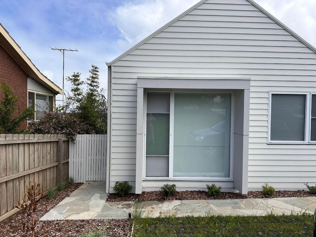 Una casa blanca con una ventana en el costado. en Private Getaway - Portarlington!, en Portarlington