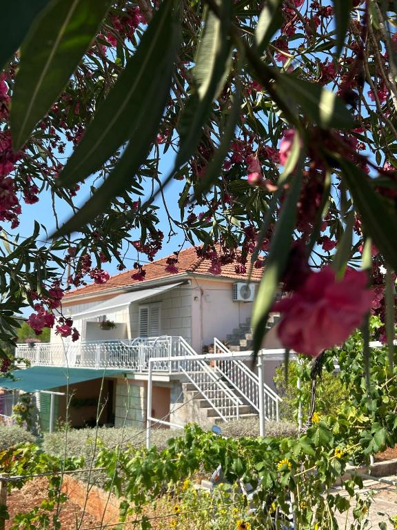 a white house with a balcony and some flowers at Korčula Guest House in Korčula