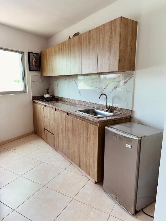 a kitchen with wooden cabinets and a sink and a dishwasher at Puerto Azul in Puerto Colombia