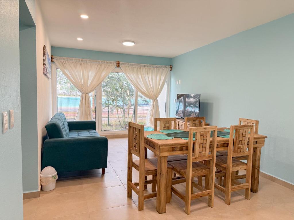 a dining room with a table and chairs and a couch at Apartamento Fina Dream Lagoon in Veracruz