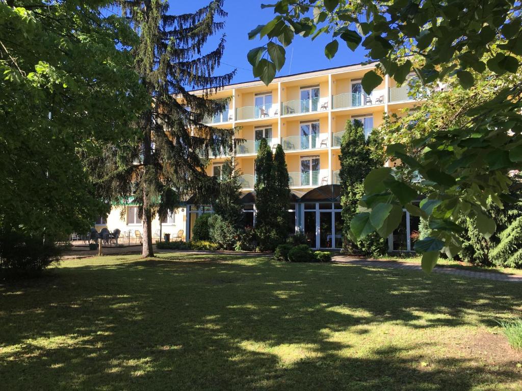 un gran edificio con árboles delante de él en Solaris Hotel, en Balatonföldvár