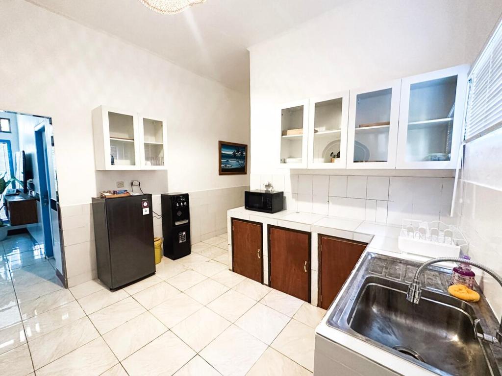 La cuisine est équipée d'un évier et d'un réfrigérateur noir. dans l'établissement Tony's Villa 1233 Seahorse Lane Gili Trawangan, à Gili Trawangan