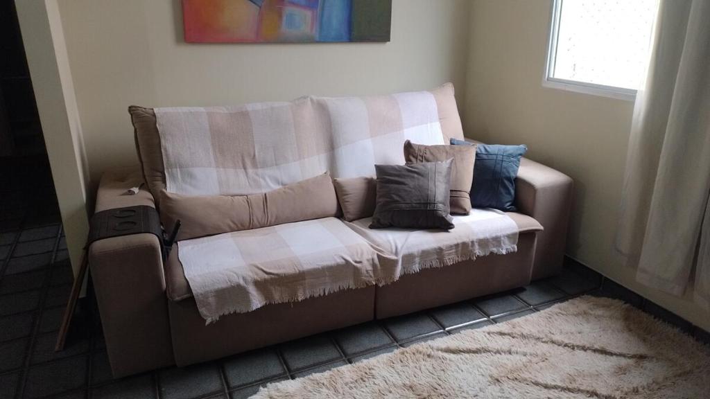 a couch with pillows on it in a room at 2 bedrooms 2 bathrooms shopp beach wifi in Vila Velha