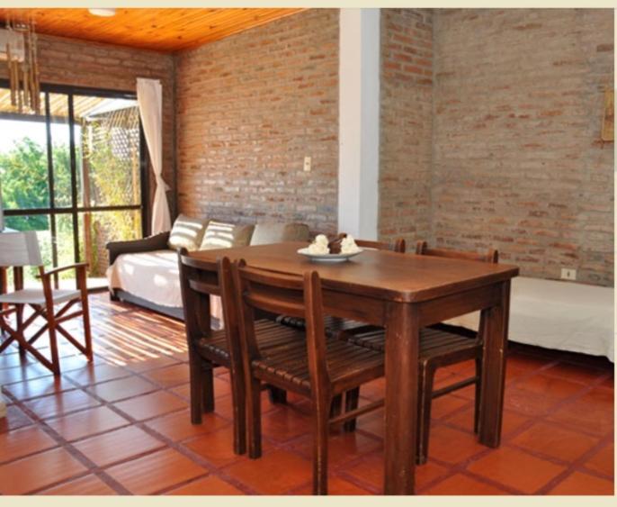 a dining room with a table and chairs and a bed at Del Barranco in San Gregorio de Polanco
