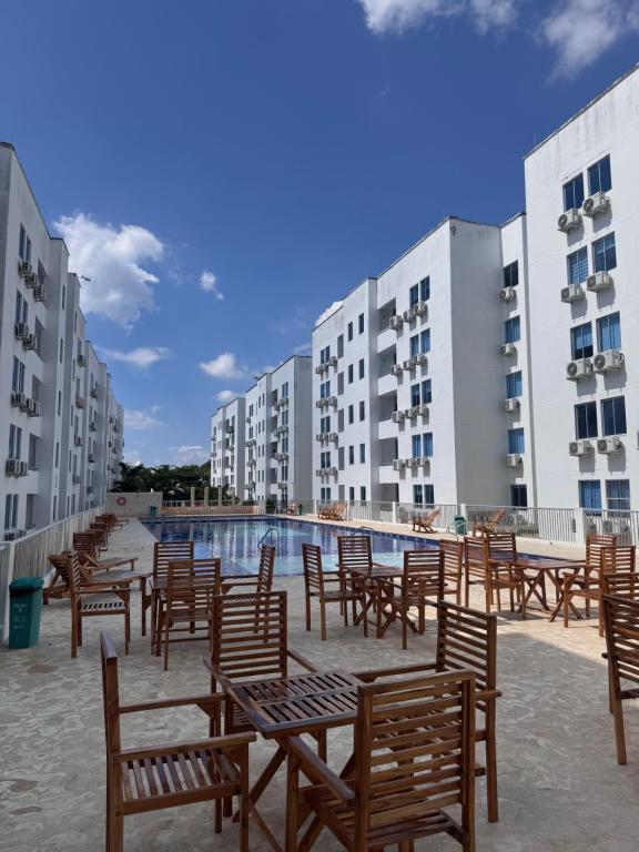 a group of chairs and a swimming pool with buildings at Apartamento Caribe Coveñas 102 in Coveñas