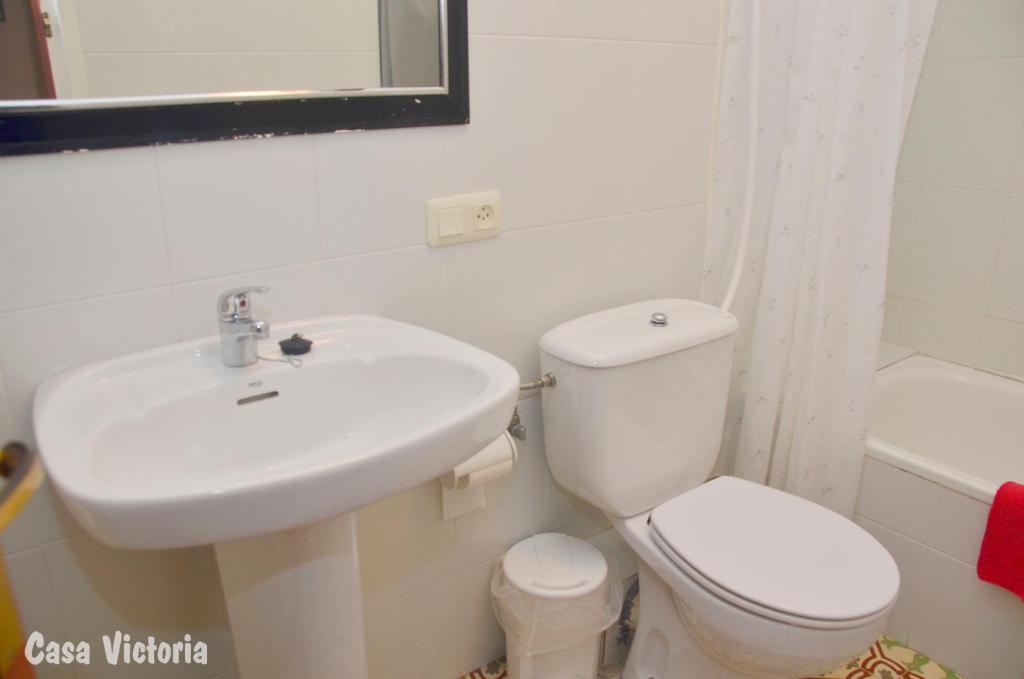 a white bathroom with a sink and a toilet at Casa Victoria in La Vilella Baixa