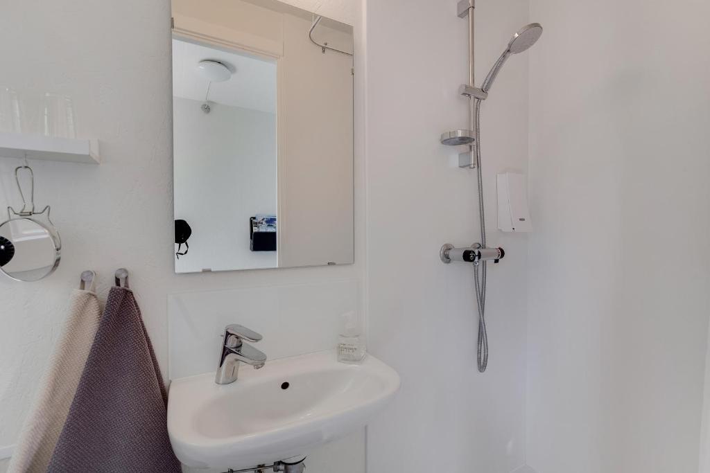 bagno bianco con lavandino e doccia di Ølholm Cottage a Stege