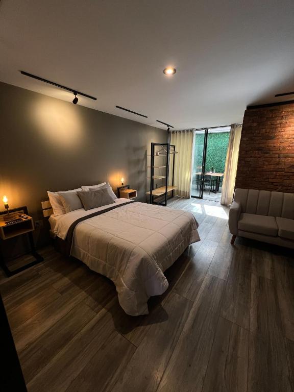 a bedroom with a large bed and a couch at Solar Deluxe Arequipa in Arequipa
