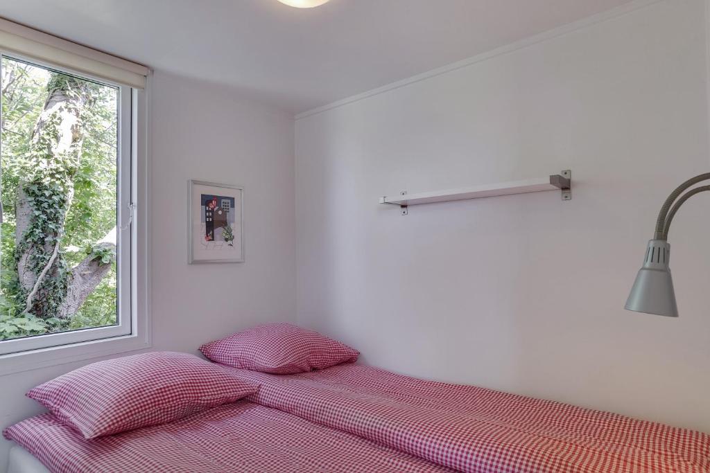 Posto letto in una camera bianca con finestra di Ølholm Cottage a Stege