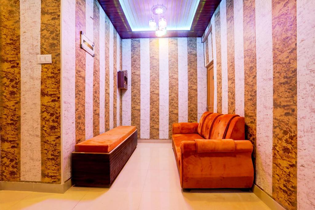 una habitación con una silla y un banco en ella en HOTEL O ELEGANT, en Prayagraj