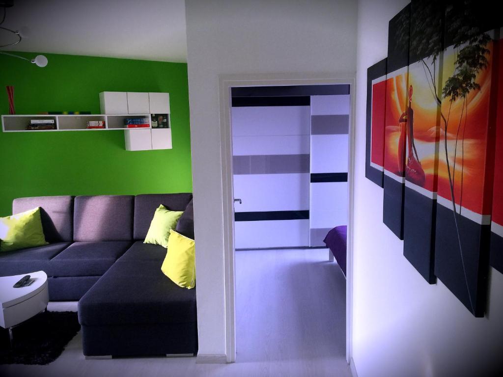 uma sala de estar com um sofá roxo e paredes verdes em Apartment Alan em Rijeka