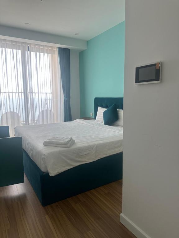 a bedroom with a large bed with blue walls at Vy hillside the apartment sunset town city in Phu Quoc